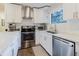 Modern kitchen with stainless steel appliances, white cabinets, and granite countertops at 138 69Th N Ave, St Petersburg, FL 33702