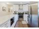 Modern kitchen with stainless steel appliances, white cabinets, and granite countertops at 138 69Th N Ave, St Petersburg, FL 33702