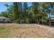 View of a spacious back yard with many mature trees, play equipment and fencing at 14 S Meteor Ave, Clearwater, FL 33765