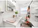 Bright bathroom with stylish vanity, marble wall tile, and colorful shower curtain at 14 S Meteor Ave, Clearwater, FL 33765