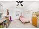 Bright bedroom with hardwood flooring, a ceiling fan, and closet shelving at 14 S Meteor Ave, Clearwater, FL 33765