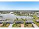 An aerial view showcases the home’s waterfront location with its verdant lawn and tranquil lake views at 1405 W Del Webb Blvd, Sun City Center, FL 33573