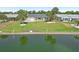 Waterfront backyard featuring a well-manicured lawn, mature palm trees, and a tranquil canal at 1405 W Del Webb Blvd, Sun City Center, FL 33573