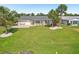 Spacious backyard featuring a patio area, lush lawn, and mature landscaping with palm trees at 1405 W Del Webb Blvd, Sun City Center, FL 33573