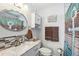 Tastefully designed bathroom with stone tile accent wall, vanity, and round mirror at 1405 W Del Webb Blvd, Sun City Center, FL 33573