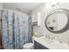 Cozy bathroom with seashell shower curtain, vanity, and round mirror at 1405 W Del Webb Blvd, Sun City Center, FL 33573