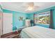 Well-lit bedroom with ceiling fan, wood floors, and a large window at 1405 W Del Webb Blvd, Sun City Center, FL 33573