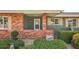Home exterior with red brick accent wall, painted green siding and manicured landscaping at 1405 W Del Webb Blvd, Sun City Center, FL 33573