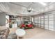 View of the garage displaying a golf cart, door, storage shelves, and a table with seating at 1405 W Del Webb Blvd, Sun City Center, FL 33573