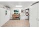 View of the garage showcasing tile flooring, built in cabinets, and a wooden workbench with a window at 1405 W Del Webb Blvd, Sun City Center, FL 33573