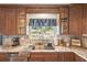 Charming kitchen with granite countertops, stainless steel sink, and wood cabinetry at 1405 W Del Webb Blvd, Sun City Center, FL 33573