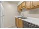 Functional kitchen with wooden cabinets, white countertops, double sink, and essential appliances at 14317 Hanging Moss Cir # 202, Tampa, FL 33613