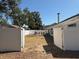 Spacious backyard enclosed by a white fence with a patio and outdoor furniture at 1710 Tallowtree Cir, Valrico, FL 33594
