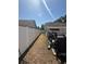 Long narrow backyard with a white fence, patio with grill and weight lifting equipment at 1710 Tallowtree Cir, Valrico, FL 33594