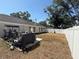 A backyard with a white fence, patio, grill, and workout equipment at 1710 Tallowtree Cir, Valrico, FL 33594