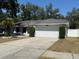Single-story home featuring a two-car garage, well-maintained lawn, and established shrubbery at 1710 Tallowtree Cir, Valrico, FL 33594