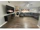 Comfortable living room featuring wood-look flooring, a stone fireplace, and a large sectional sofa at 1710 Tallowtree Cir, Valrico, FL 33594