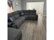 Open-concept living room with wood-look floors and a sectional couch at 1710 Tallowtree Cir, Valrico, FL 33594