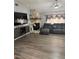 Cozy living room featuring wood-look flooring, a stone fireplace, and a comfortable sectional sofa at 1710 Tallowtree Cir, Valrico, FL 33594