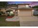 Inviting two-story home with a two-car garage, manicured lawn, and lush landscaping at 1719 Bayhill Dr, Oldsmar, FL 34677