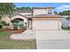 Charming two-story home featuring a two-car garage and manicured landscaping, creating an inviting curb appeal at 1719 Bayhill Dr, Oldsmar, FL 34677