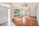 Bright living room featuring wood floors, large windows, and a mirrored wall reflecting the natural light at 1719 Bayhill Dr, Oldsmar, FL 34677