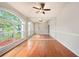 Bright living room featuring wood floors, large windows, and a mirrored wall reflecting the natural light at 1719 Bayhill Dr, Oldsmar, FL 34677