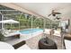 Outdoor screened-in patio features an inviting pool, sunbathing space, ceiling fans, and a dining area at 1719 Bayhill Dr, Oldsmar, FL 34677