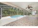 Screened-in lanai with a swimming pool, tile flooring and ceiling fans for outdoor enjoyment at 1719 Bayhill Dr, Oldsmar, FL 34677