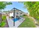Backyard patio with pergola, outdoor seating, mature landscaping, and an adjacent grassy area at 1727 New Hampshire Ne Ave, St Petersburg, FL 33703