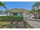 Charming single-story home with well-manicured landscaping, an attached garage, and a vibrant turquoise front door at 1727 New Hampshire Ne Ave, St Petersburg, FL 33703