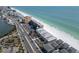 Scenic aerial view showcasing beachfront condos alongside a pristine sandy beach with turquoise ocean waters at 18650 Gulf Blvd # 313, Indian Shores, FL 33785