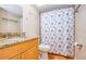 Bathroom featuring a seashell-themed shower curtain, granite counters and vanity, a mirror, and tile floors at 18650 Gulf Blvd # 313, Indian Shores, FL 33785