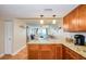 Open kitchen with granite counters, wood cabinets, and a view into the cozy living space and balcony at 18650 Gulf Blvd # 313, Indian Shores, FL 33785