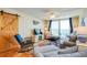 Cozy living room with ocean view balcony, barn door accent, and stylish coastal decor at 18650 Gulf Blvd # 313, Indian Shores, FL 33785