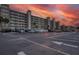 Spacious parking lot with ample spaces in front of a well maintained condo building with palm trees at sunset at 18650 Gulf Blvd # 313, Indian Shores, FL 33785