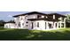 Rear of modern house featuring ample windows and a well-manicured lawn, ideal for relaxation and entertainment at 19207 Gunn Hwy, Odessa, FL 33556