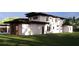 Back of modern style home with a covered patio and lush yard; a perfect blend of indoor-outdoor living at 19207 Gunn Hwy, Odessa, FL 33556