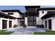 Beautifully designed modern home with grand entrance, landscaped front yard, and stylish garage doors at 19207 Gunn Hwy, Odessa, FL 33556