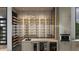 Elegant wine cellar featuring custom wood shelving, glass enclosure, and integrated beverage coolers at 19211 Gunn Hwy, Odessa, FL 33556