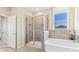 Modern bathroom featuring a glass-enclosed shower, soaking tub, and neutral tile at 19720 Gladeview Way, Land O Lakes, FL 34638