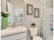 Neat and tidy bathroom with a view of the kitchen, floral shower curtain, and white sink at 19752 Gladeview Way, Land O Lakes, FL 34638