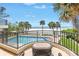 Balcony view overlooking the pool and beach with palm trees and blue skies at 19910 Gulf Boulevard # 102, Indian Shores, FL 33785