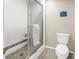 Tiled walk-in shower with glass doors and a modern toilet in this updated bathroom at 19910 Gulf Boulevard # 102, Indian Shores, FL 33785