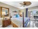 Beautiful bedroom featuring a four-poster bed, ceiling fan, and a sliding glass door to the outdoor balcony with ocean view at 19910 Gulf Boulevard # 102, Indian Shores, FL 33785