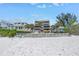Beachfront view of the condo building with a white picket fence at 19910 Gulf Boulevard # 102, Indian Shores, FL 33785