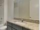 Granite counters accent the single sink bathroom vanity, tub, and matching grey cabinets at 20092 Stone Pine Cir, Lutz, FL 33558