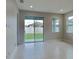 Bright living room featuring tile flooring, neutral walls, and a sliding door leading to the backyard at 20092 Stone Pine Cir, Lutz, FL 33558