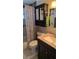 Bathroom featuring a black vanity with pink marble countertop, a matching medicine cabinet, and patterned shower curtain at 2035 Erin Dr, Holiday, FL 34690