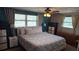 Bright bedroom with a large bed, ceiling fan, two windows, and ample closet space at 2035 Erin Dr, Holiday, FL 34690